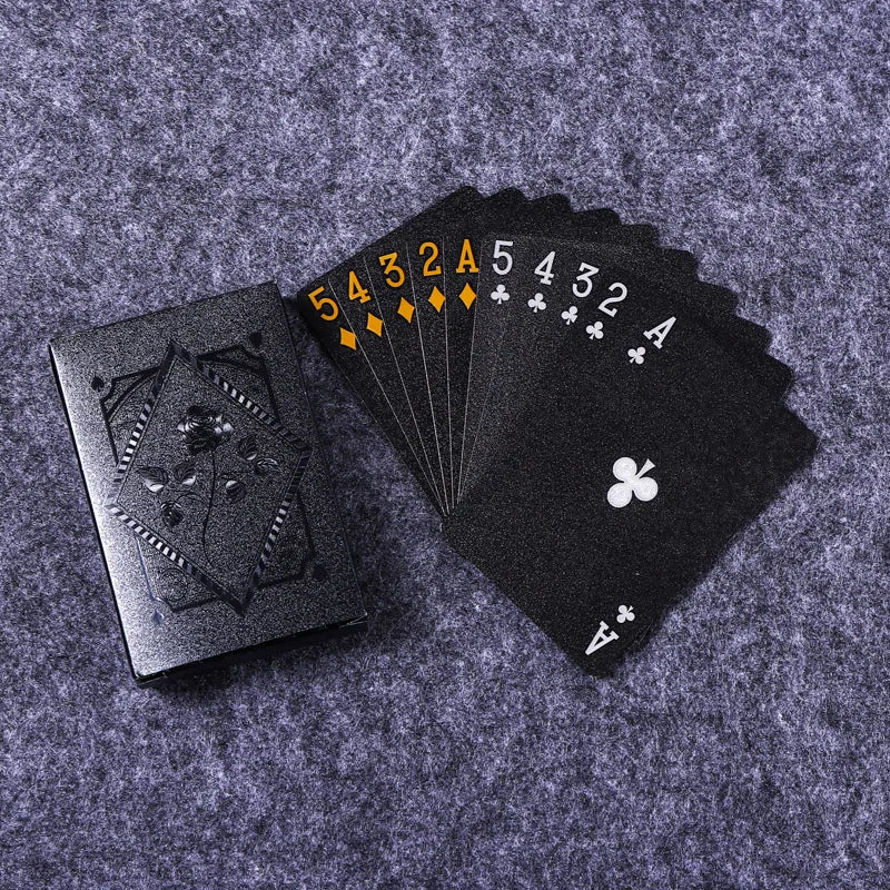 Waterproof black playing cards spread out with a stylish card box, ideal for poker and magic games.